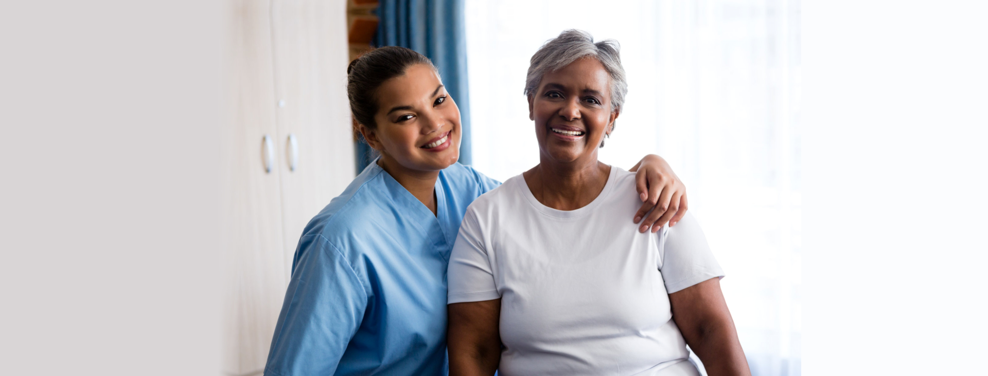 senior woman and nurse facing each other while smiling